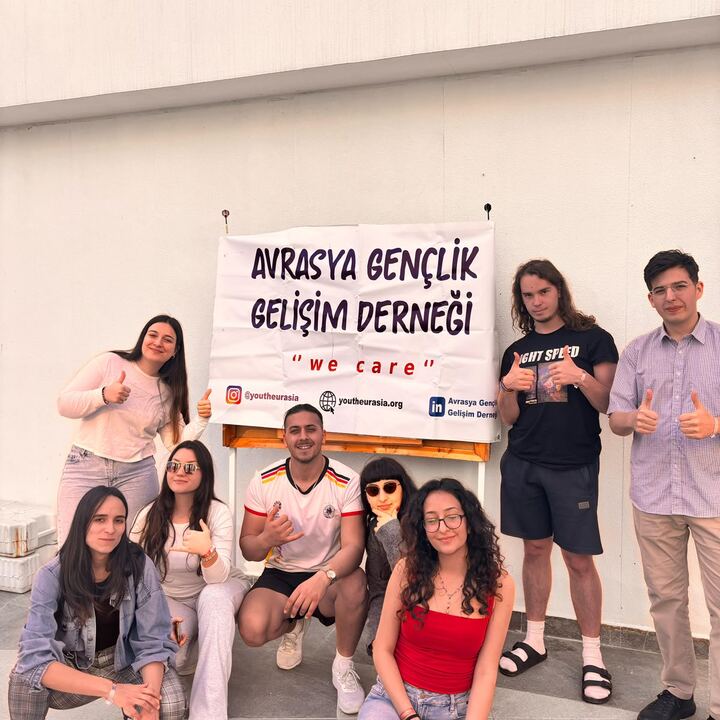 We Care pankartı önünde gençler